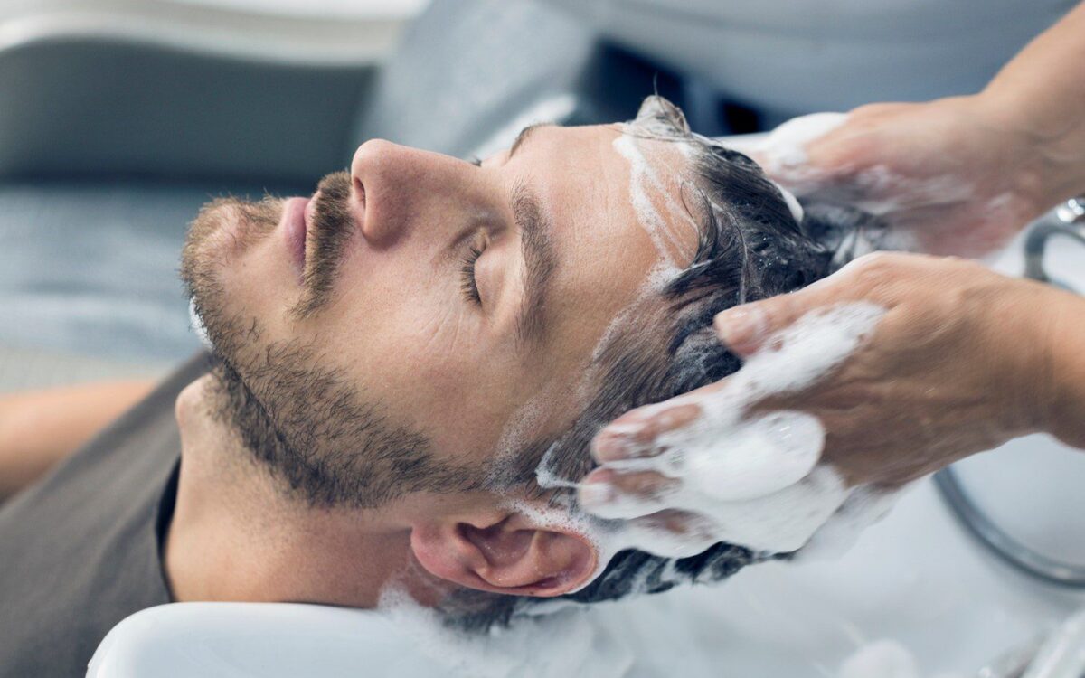 Man receiving a professional hair wash at a barber shop