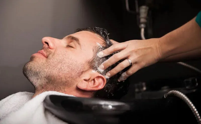 Man receiving scalp treatment at a salon